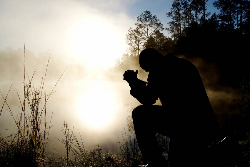 Silhouette praying at dawn